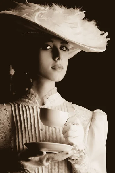 Vrouw in witte Victoriaanse tijdperk kleren met kopje thee — Stockfoto