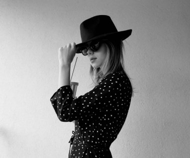 Bir içki ile şapka ve güneş gözlüğü genç kadın.