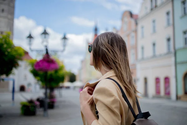 Donna in occhiali da sole e zaino in piazza del centro storico. Polonia — Foto Stock