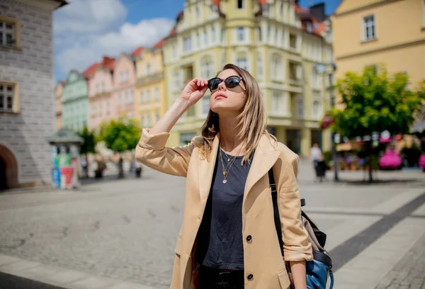Γυναίκα με γυαλιά ηλίου και σακίδιο στην πλατεία του κέντρου της πόλης. Πολωνία — Φωτογραφία Αρχείου