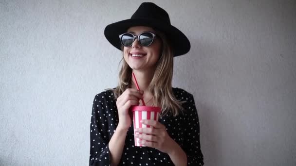 Bir içki ile şapka ve güneş gözlüğü kadın — Stok video