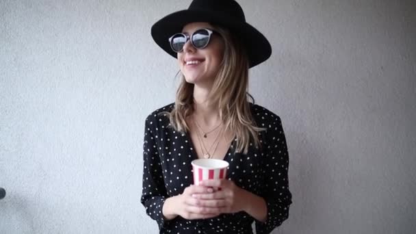 Mulher de chapéu e óculos de sol com uma bebida — Vídeo de Stock