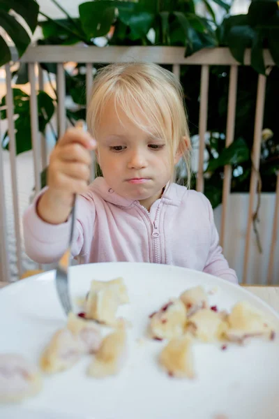 Маленькая девочка ест пельмени в кафе — стоковое фото