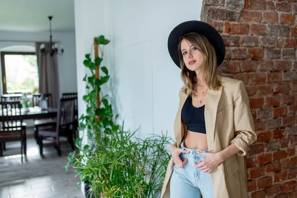 Menina de estilo em chapéu e roupas em uma casa — Fotografia de Stock