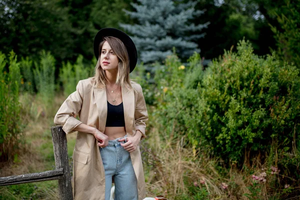 古い田舎の庭で帽子とジャケットの女性 — ストック写真