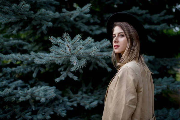 Stile donna in cappello e giacca vicino pino — Foto Stock