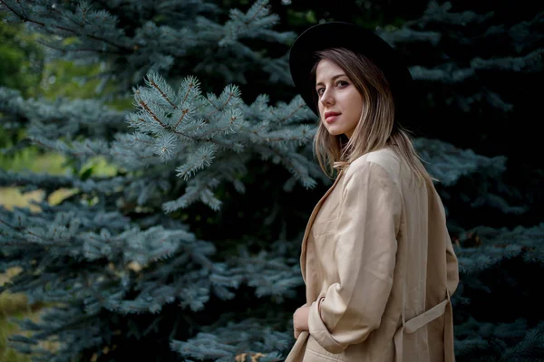 Mujer de estilo en sombrero y chaqueta cerca de pino — Foto de Stock