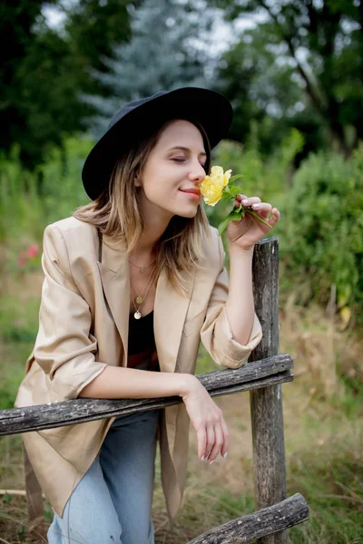 Mujer en sombrero y chaqueta en el viejo jardín del campo — Foto de Stock