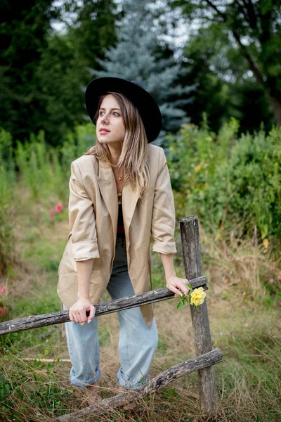 Mujer en sombrero y chaqueta en el viejo jardín del campo —  Fotos de Stock