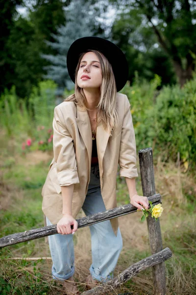 Mulher de chapéu e jaqueta no velho jardim rural — Fotografia de Stock