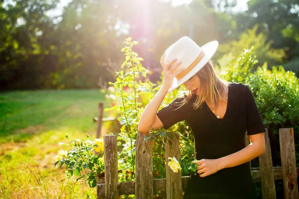 Frau mit Hut im sommerlichen Garten — Stockfoto