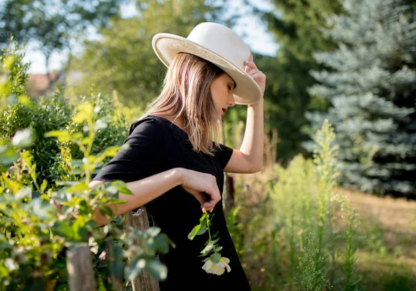 Mujer en sombrero en un jardín rural de verano —  Fotos de Stock