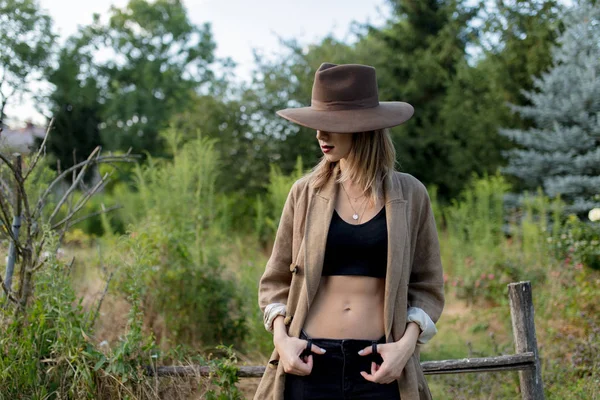 Mulher de chapéu em um jardim rural de verão — Fotografia de Stock