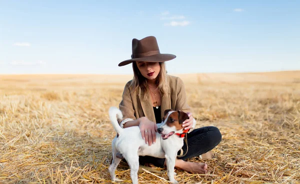 Femme en chapeau avec chien sur le terrain — Photo