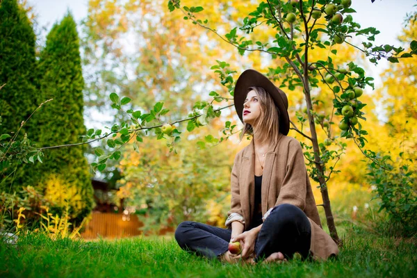 Mulher ter um relaxar em um jardim perto de árvore de maçã jovem — Fotografia de Stock