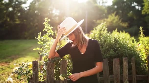 Donna in cappello in un giardino di campagna estivo — Video Stock