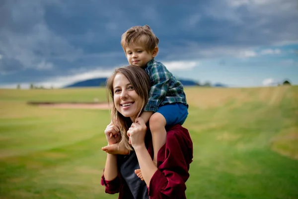 Madre tener una diversión con un hijo en un prado en las montañas — Foto de Stock