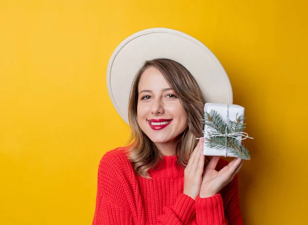 Молодая удивленная женщина в красном свитере с подарочной коробкой — стоковое фото