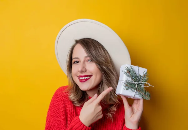 Jeune femme souriante en pull rouge avec boîte cadeau — Photo