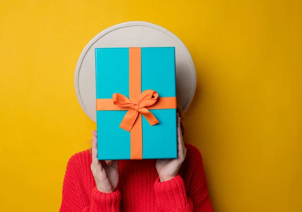 Young surprised woman in red sweater with gift box — Stock Photo, Image