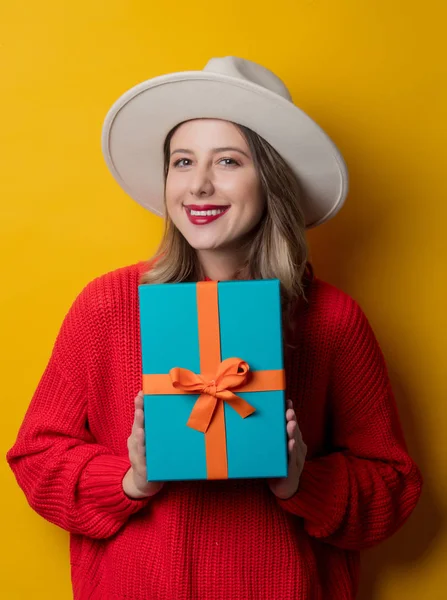 Mujer sonriente joven en suéter rojo con caja de regalo —  Fotos de Stock