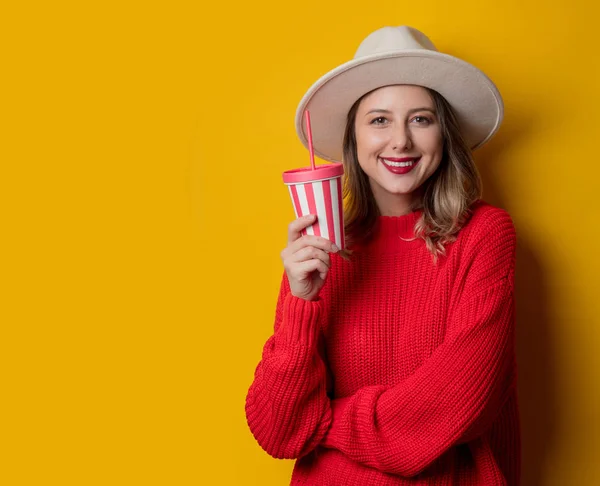 Žena v klobouku a červeném svetru s nápojem — Stock fotografie