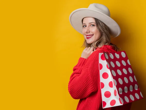 Mulher de chapéu e sacos de compras — Fotografia de Stock