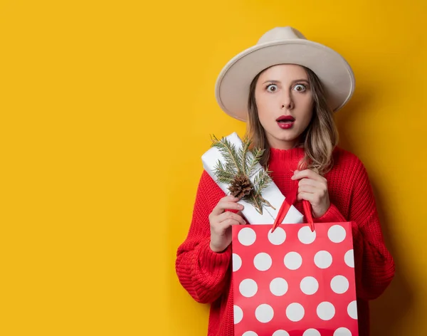 Vrouw in rode trui met geschenk doos en boodschappentas — Stockfoto