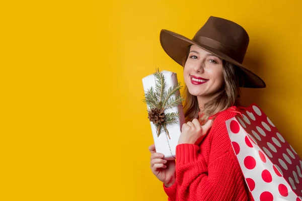 Donna in maglione rosso con confezione regalo e shopping bag — Foto Stock