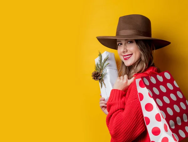 Mujer en jersey rojo con caja de regalo y bolsa de compras —  Fotos de Stock