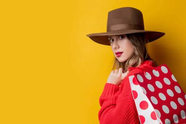 Mulher de chapéu e sacos de compras — Fotografia de Stock