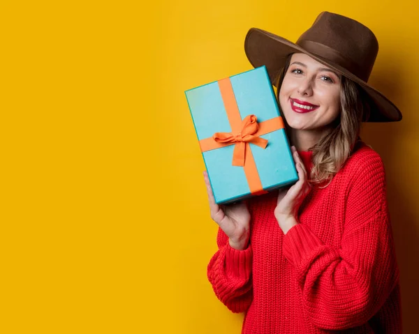 Jonge lachende vrouw in rode trui met geschenk doos — Stockfoto