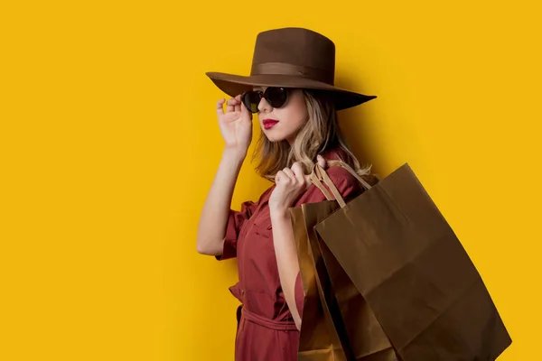 Elegant kvinna i solglasögon och med shoppingväskor — Stockfoto