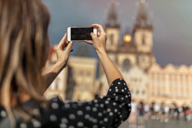 cep telefonu ile kadın Prag'da eski şehir bir çekim almak