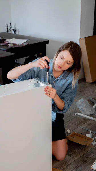 Woman with screwdriver instaling a furniture at home personally — Stock Photo, Image