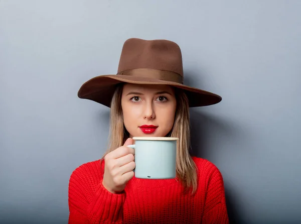 Vrouw in rode trui en muts met kopje koffie — Stockfoto