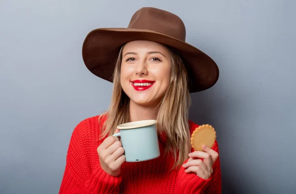 Vrouw in rode trui en beker met cookie — Stockfoto