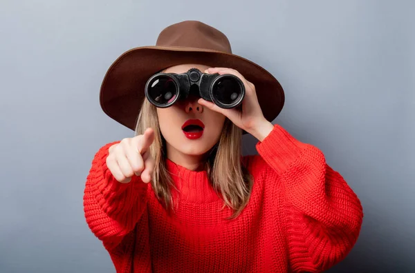 Donna in maglione rosso e cappello con binocolo — Foto Stock