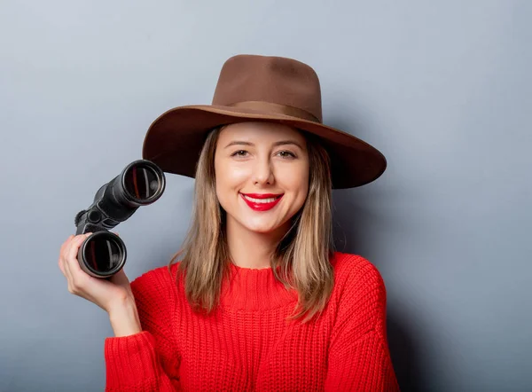 Frau in rotem Pullover und Hut mit Fernglas — Stockfoto