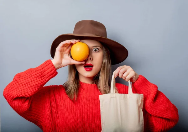 Mujer en suéter rojo con naranja y bolsa —  Fotos de Stock