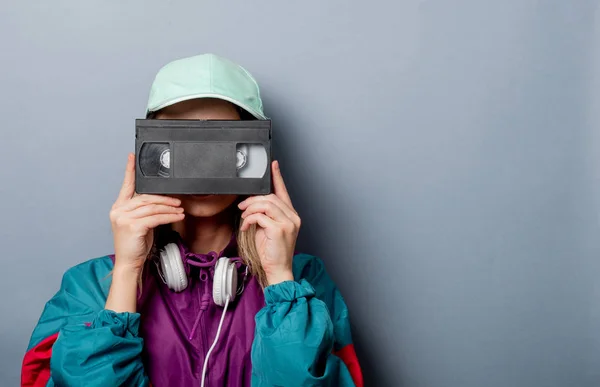 Style woman in 90s clothes style with VHS video cassette — Stock Photo, Image