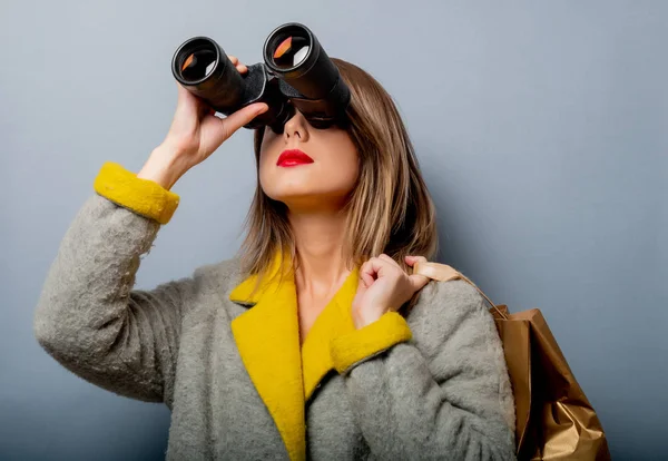 Mujer de abrigo con bolsa de compras y binoculares —  Fotos de Stock