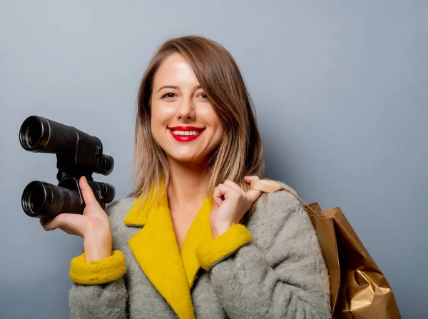 Vrouw in de vacht met boodschappentas en verrekijker — Stockfoto