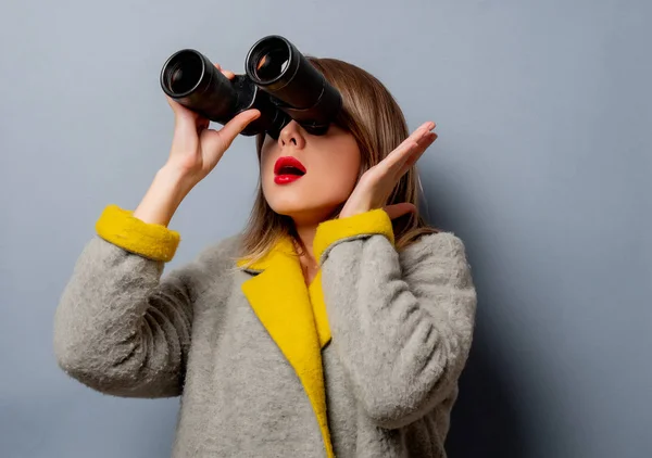 Frau im Mantel mit Fernglas — Stockfoto