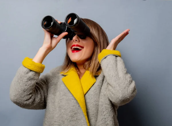 Style woman in coat with binoculars — Stock Photo, Image