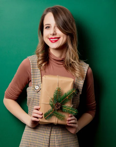 緑の背景にクリスマスの贈り物とヴィンテージのドレスの女性 — ストック写真