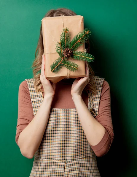 Kobieta w sukience vintage z prezentem świątecznym na zielonym tle — Zdjęcie stockowe
