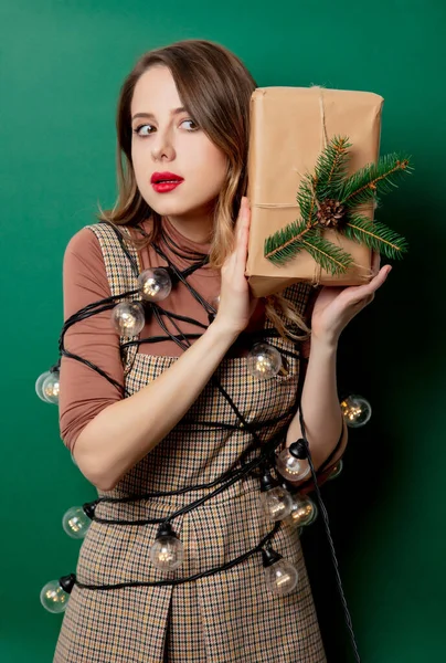 Žena ve vinobraní šaty s vánoční dárek a víla světla na g — Stock fotografie