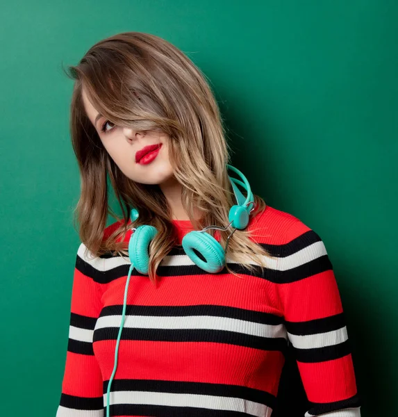 Женщина в полосатом свитере с наушниками — стоковое фото