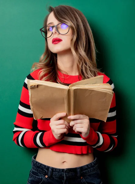 Femme en pull rayé et lunettes avec livre — Photo